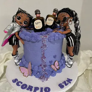 a group of dolls on top of a cake