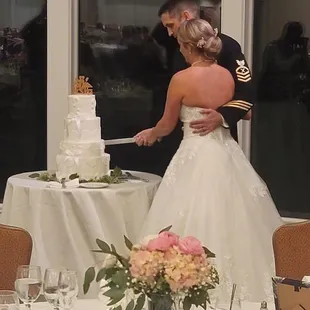 a bride and groom cutting their wedding cake