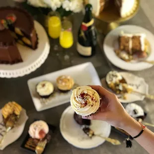 a hand holding a cupcake