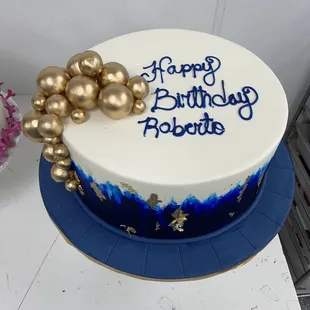 a birthday cake with blue and gold decorations