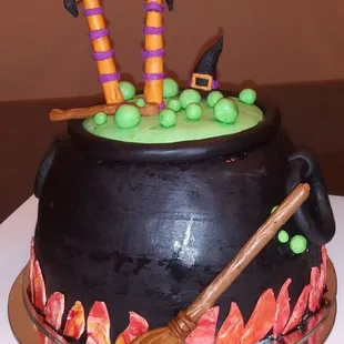 a black caulder with green and orange decorations