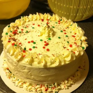 a cake with white frosting and sprinkles