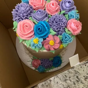 Buttercream flowers on a white 6" cake. Stunning arrangement