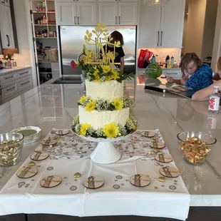 a three tiered cake with yellow flowers