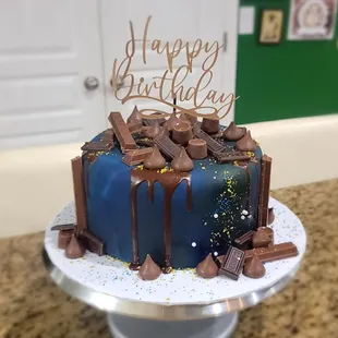 Chocolate cake cover with fondant and a lot of chocolate candies on top
