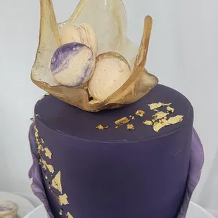 elegant Purple fondant cake with sugar sail filled with macaroons on top