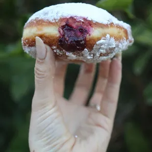 a hand holding a doughnut