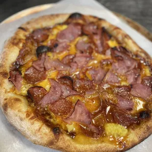 a pizza with ham and pineapple toppings