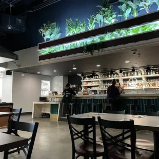 a restaurant with a fish tank above the bar