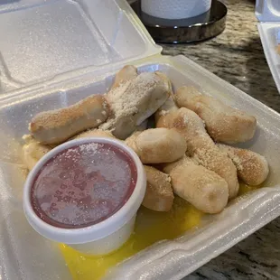 a tray of breadsticks and dipping sauce