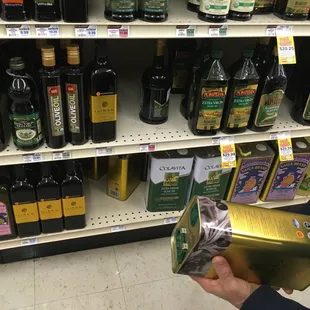 a person holding a box of olive oil