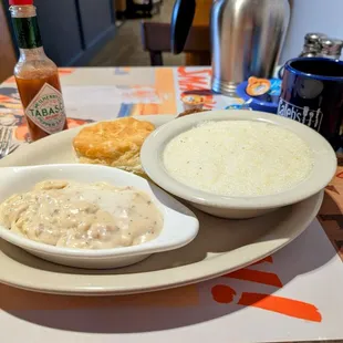 Biscuit, gravy, big bowl of grits, peeking sausage patty.