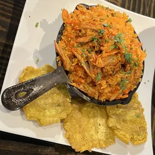 Arroz con pollo a chicken and rice dish with tostones/green plantains.