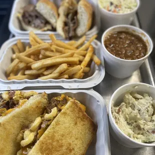 a tray of food including a sandwich, french fries, coleslaw and coleslaw