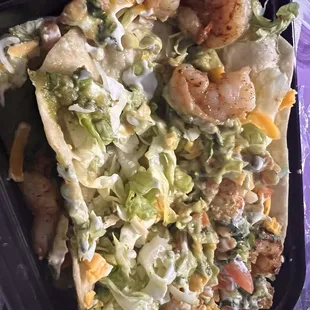 Taco salad shrimp you can also see sour cream and Guac on it.