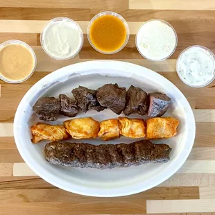 A perfect pairing of flavorful kabobs and a tantalizing assortment of sauces, offering a delightful flavor adventure for your taste buds.