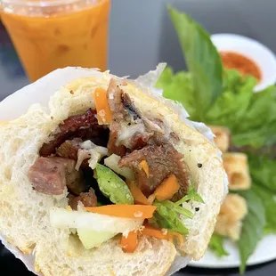 BBQ Grilled Pork Bánh mì sandwich (Thai tea with egg rolls in background)