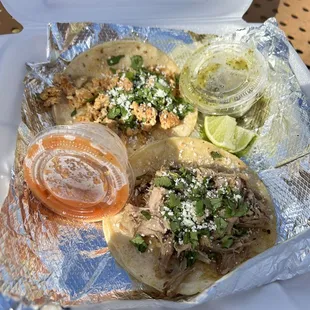 a variety of tacos in a styrofoam container