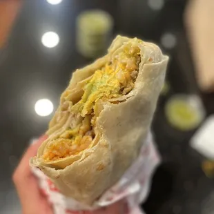 a hand holding a burrito