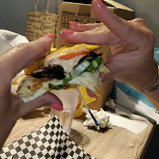 two hands holding a sandwich