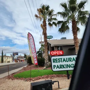 a restaurant parking sign and palm trees