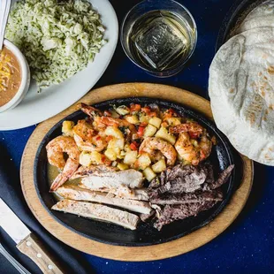 Our Puebla plate featuring shrimp, beef and chicken fajitas. Enjoy it with our homemade tortillas, cilantro rice and a pour of tequila