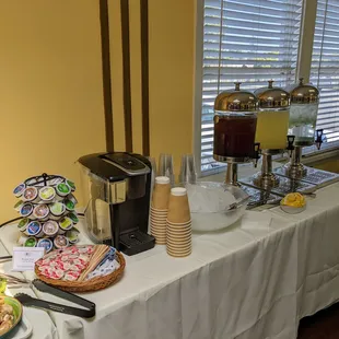 Beverage bar.  Keurig machine with a variety of coffees, teas, and hot chocolate; iced tea, lemonade, &amp; spring water with lime in dispensers