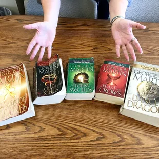 Colleague Tammy (hands in pic) clued me to Game of Thrones set only 50 cents/book in lobby rummage-sale -"Winter is Coming"