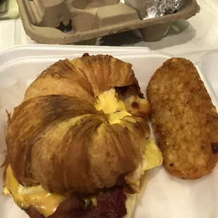 Croissant sandwich with bacon &amp; hash browns.