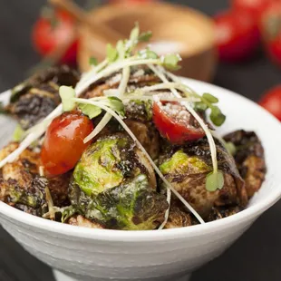 a bowl of food with tomatoes and broccoli