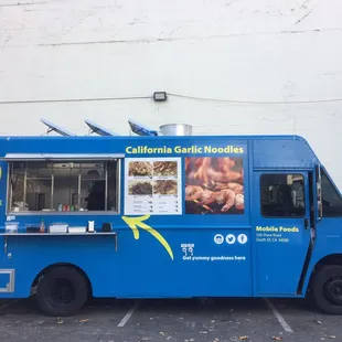 a blue food truck parked in a parking lot