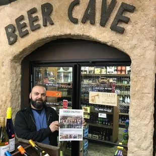 a man standing in front of a beer cave