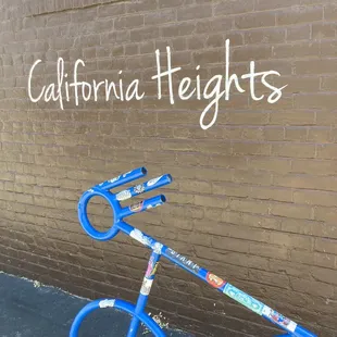 a blue bicycle leaning against a brick wall