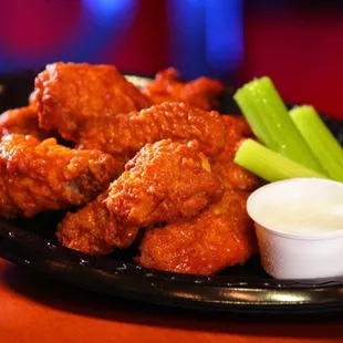 a plate of buffalo wings and celery