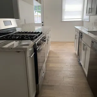 Beautiful installation of new kitchen cabinets, granite countertops, sink, faucets, recessed lighting and hardwood flooring etc