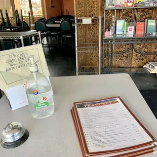 Order/pickup table compete with hand sanitizer, menus and a bell to call for assistance