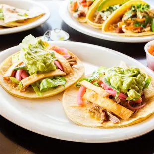 a variety of tacos on plates