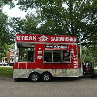 a red food truck parked in a parking lot