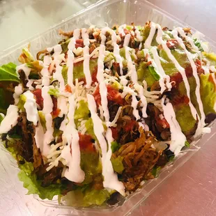 A taste of both worlds! A fresh bed of romain lettuce with a layer of savory carnitas, cheese, sourcream, and flavorful salsa!