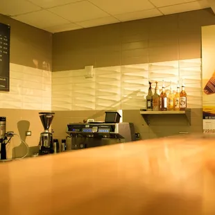 a coffee shop counter with a surfboard on the wall