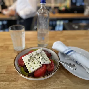 Greek Salad. Tomatoes, Cucumber, Red Onions, Olives and Peppers with oil &amp; vinegar topped with feta &amp; herbs.