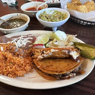 Queso Birria tacos with rice and beans.