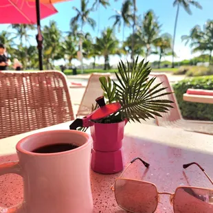 a cup of coffee and sunglasses on a table