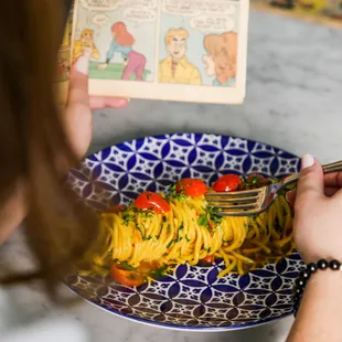 a plate of pasta and a book