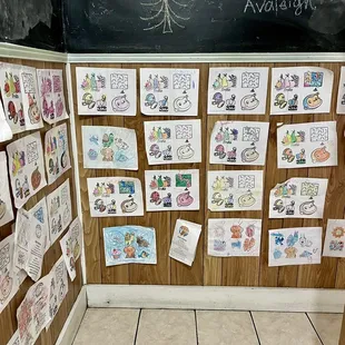 (Coming out from restrooms) Walls are covered in coloring pages from children who have visited and cute sayings written in chalk.