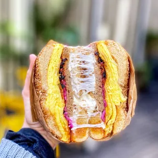 a hand holding a sandwich