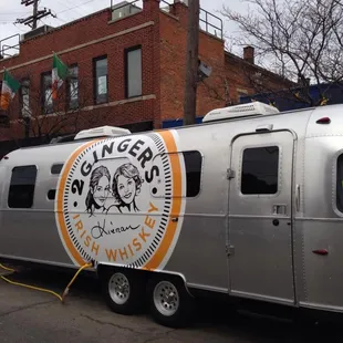 a silver trailer parked in front of a brick building
