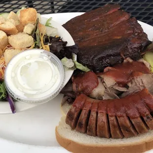 Three way BBQ sampler: ribs, brisket, and sausage with two sides, side salad, plus another side not pictured.