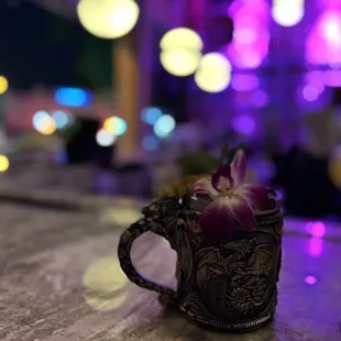 a close up of a cup with a flower in it