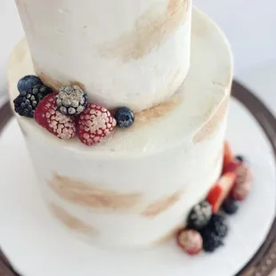 a three tiered cake with berries on top